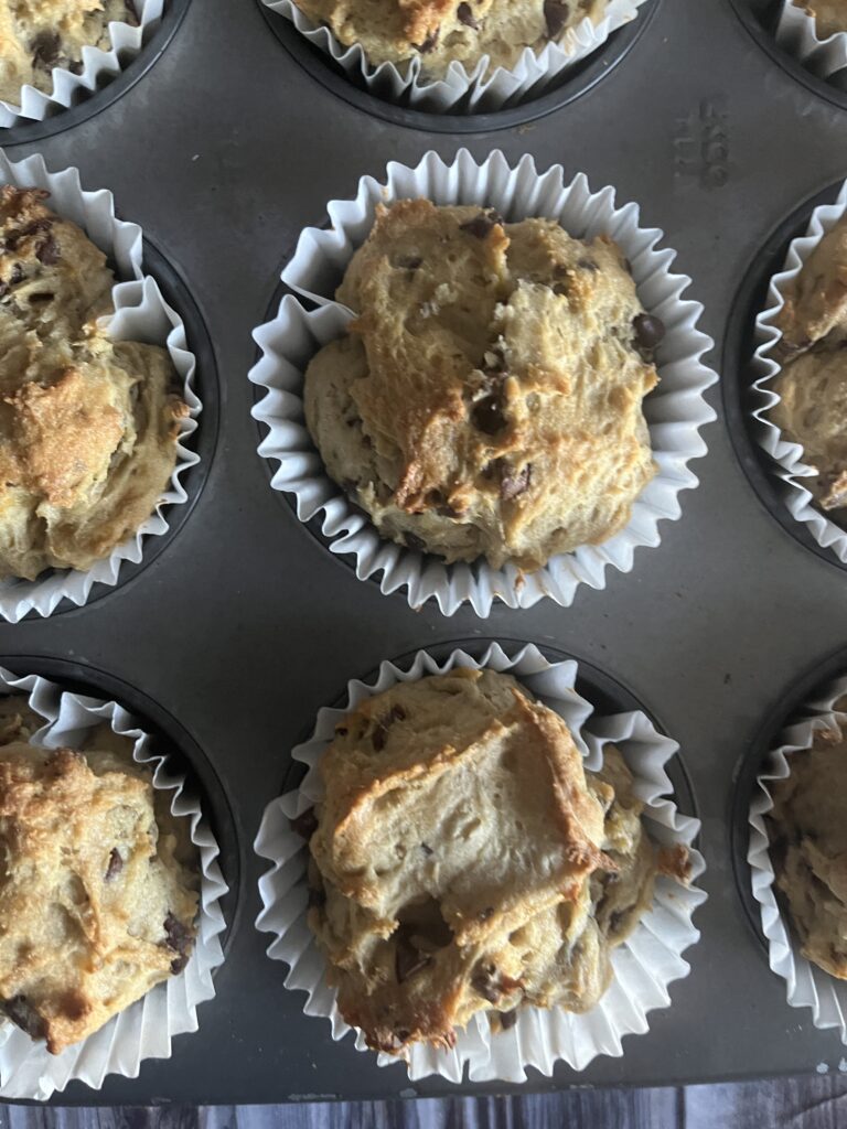 A photo of gluten-free banana chocolate chip muffins in a muffin tin. 