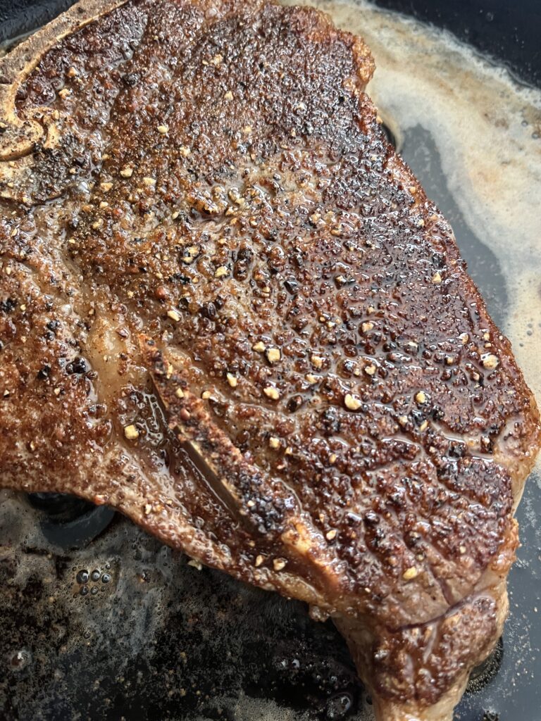 Up close photo of steak in a cast iron skillet