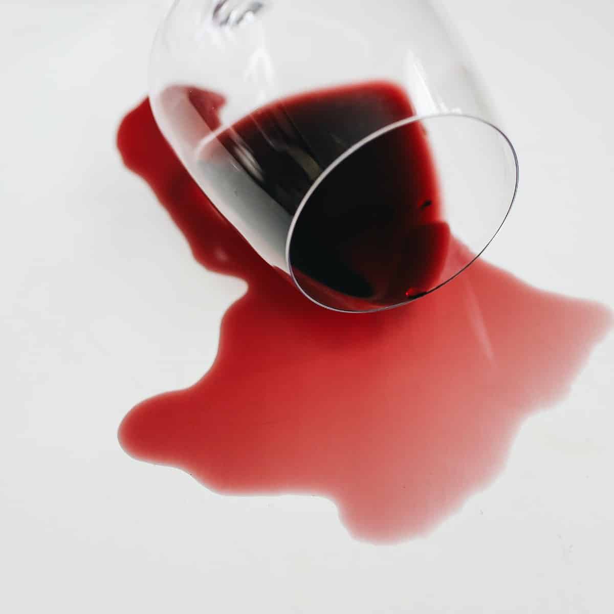 Photo of spilled red wine and a glass