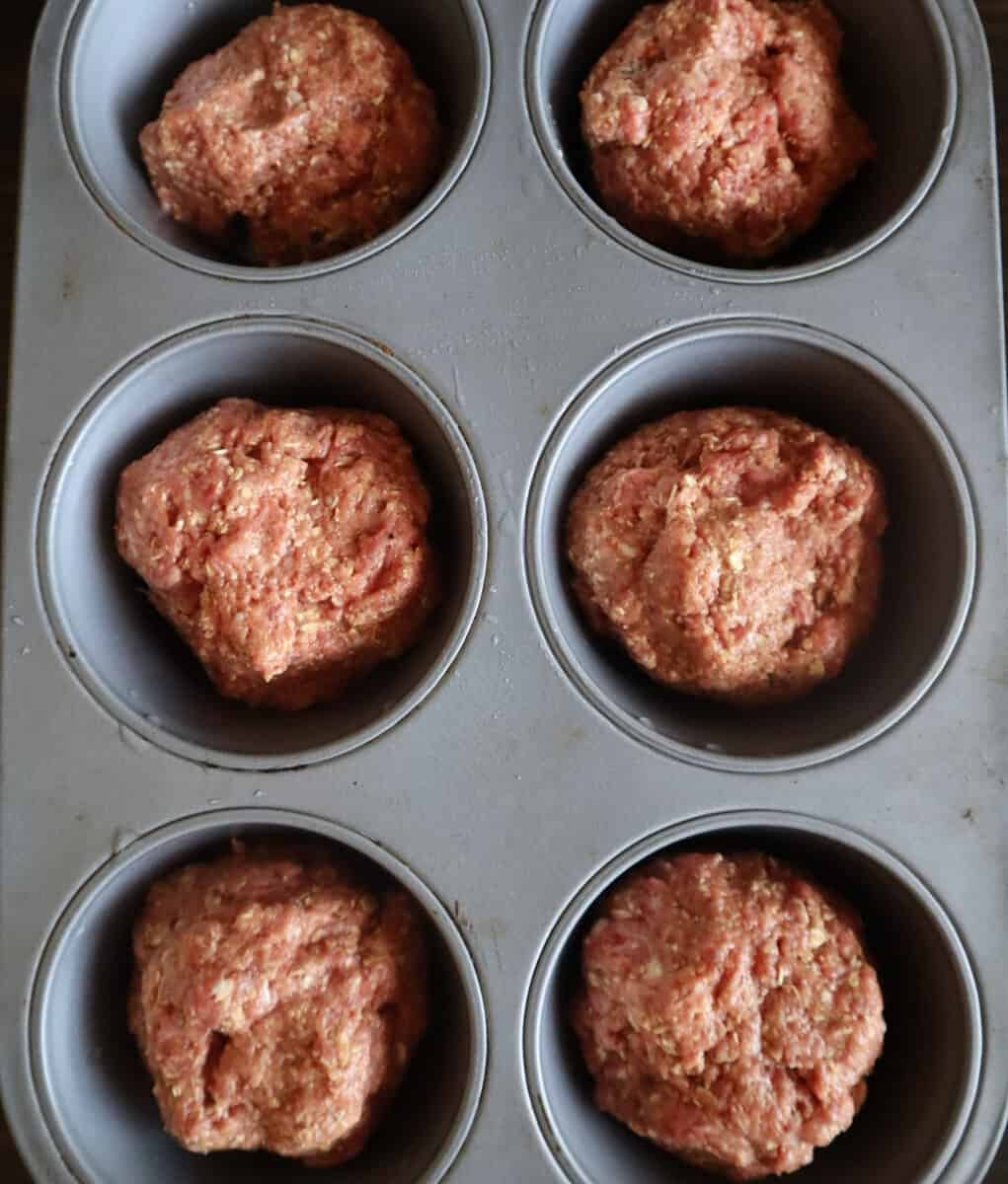 Photo of gluten free meatloaf muffins shaped and before baking in muffin tin.