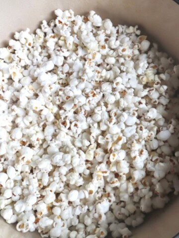 A photo of homemade popcorn cooked in a blue enameled cast iron dutch oven.